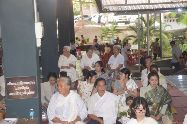 ຜູ້ເຖົ້າຜູ້ແກ່ ແລະ ລູກຫຼານນັ່ງລໍຖ້າຮ່ວມບຸນເຂົ້າສະຫຼາກຢູ່ສາລາ.
