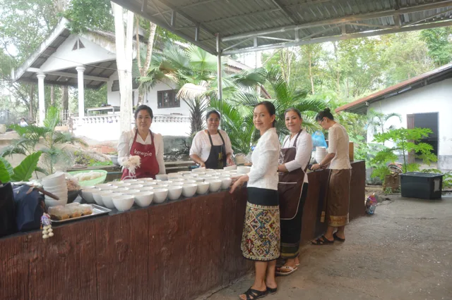 ແມ່ຄົວຈັດກຽມຖ້ວຍອາຫານໄວ້ລ້ຽງຍາດໂຍມທີ່ມາຮ່ວມບຸນ.