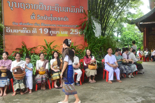 ຍາດໂຍມນັ່ງລໍຖ້າຖືກະຕິບເຄື່ອງໄທຍະທານ ໃນວັນບຸນເຂົ້າສະຫຼາກ.