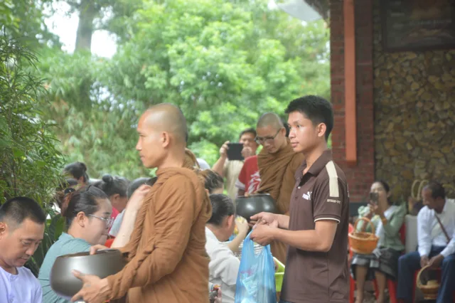 ພຣະສົງອຸ້ມບາດຍ່າງຮັບບິນທະບາດ ຈາກຍາດໂຍມຕາມແຖວ.
