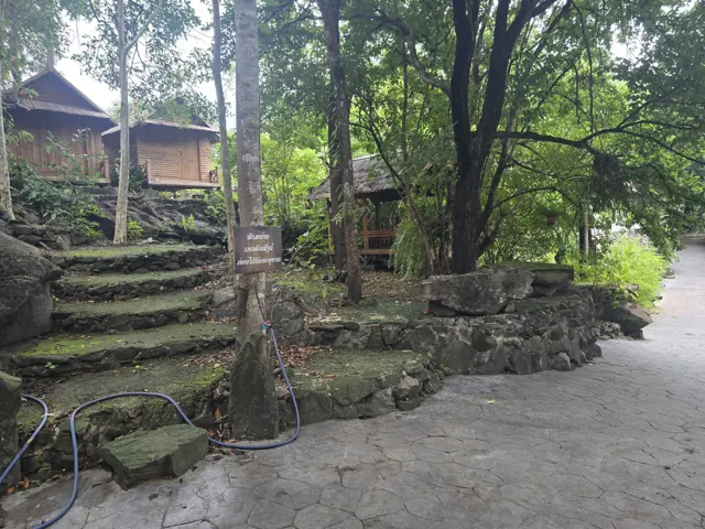 ຂັ້ນໄດຫີນ ແລະ ທາງຍ່າງທ່າມກາງຮົ່ມໄມ້ພາຍໃນວັດ.